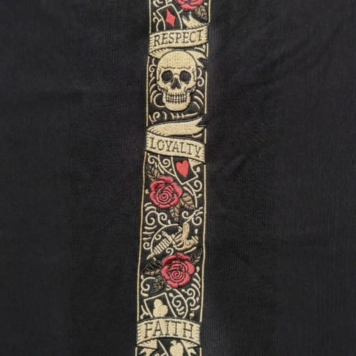 Nahaufnahme des LFR Stickbands mit Respect, Loyalty und Faith, Totenkopf und Rosen auf schwarzem Stoff