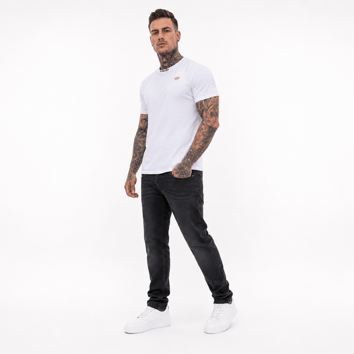 Trust nobody embroidery T-shirt wit gedragen door model, voorkant schuin met gouden MVL logo op de borst