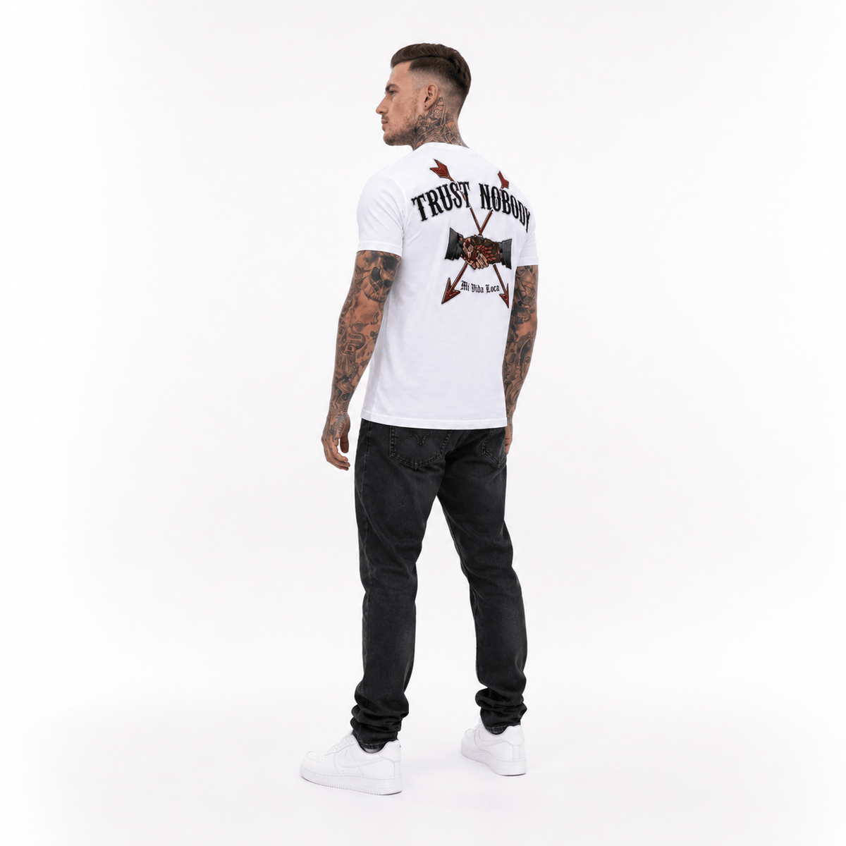 Trust nobody embroidery T-shirt wit gedragen door model, schuin van achteren met de geborduurde rugprint