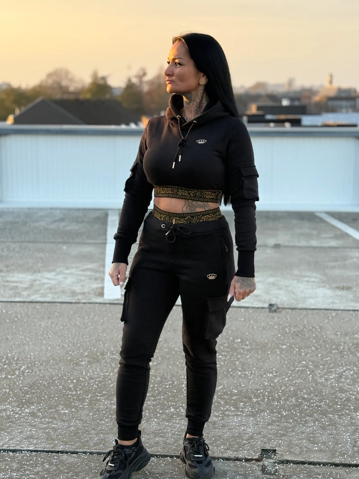 Modelo con sudadera y pantalón jogger de mujer MVL Meander en una azotea al atardecer