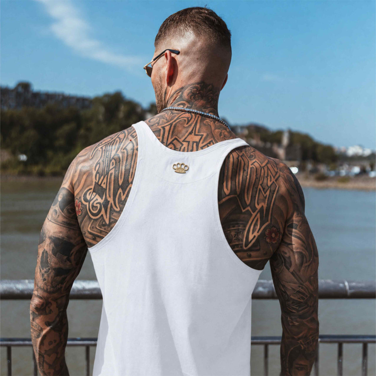 Espalda de la camiseta de tirantes MVL Original streetwear blanca llevada por modelo con tatuajes en la espalda