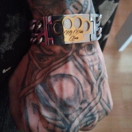 Zbliżenie bransoletki MVL ze złotym logo MVL i grawerem Mi Vida Loca na nadgarstku
